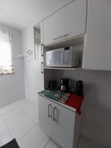 a kitchen with a microwave and a stove top oven at Apto Sow Shop in Campos dos Goytacazes