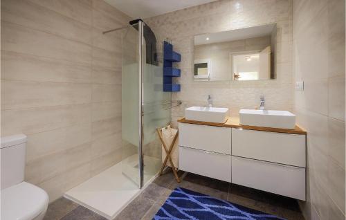 a bathroom with two sinks and a glass shower at 3 Bedroom Awesome Apartment In Pineda De Mar in Pineda de Mar