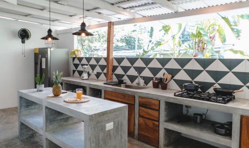 een keuken met een aanrecht en een fornuis top oven bij Cuatro Vientos Lodge & Apartments in Santa Teresa Beach