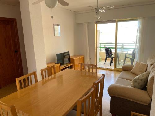 - un salon avec une table en bois et un canapé dans l'établissement Apartamento en segunda linea en playa de Gandia, à Playa de Gandia
