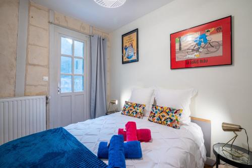 a bedroom with a bed with blue and red pillows at Mille Sabords 4 pers à 20 minutes de Beauval in Montrichard