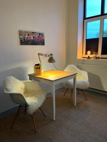a desk with a lamp and two chairs in a room at Room 8 - Hawkraft kulturhotel in Vestervig