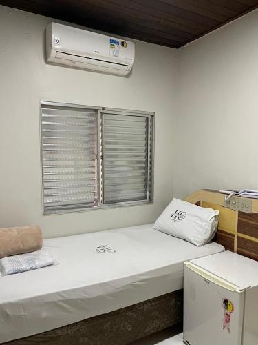 a small room with a bed and a window at Hotel Carrão in Sao Paulo