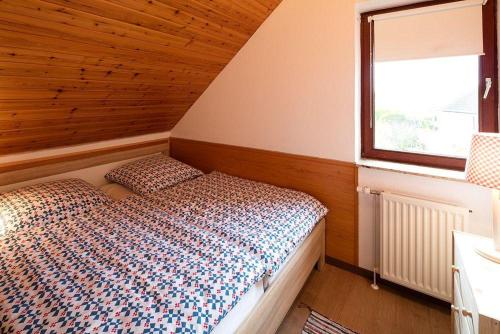 um quarto com uma cama e uma janela em Ferienwohnung-Am-Knurrhahn-3 em Scharbeutz