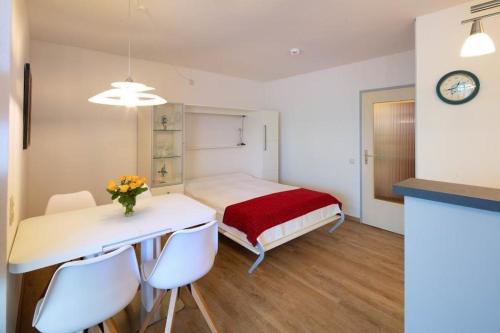 a bedroom with a bed and a table and chairs at Prinz-Hamlet-App-133-in-Pelzerhaken in Neustadt in Holstein