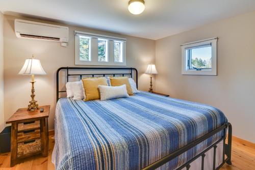 um quarto com uma cama com um edredão azul e 2 janelas em Coastal Retreat Waterfront Right Outside Windows! em Tremont