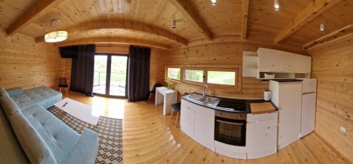 einen Blick über eine Küche und ein Wohnzimmer in einem Blockhaus in der Unterkunft NEO resort jezero Bruje in Erdevik