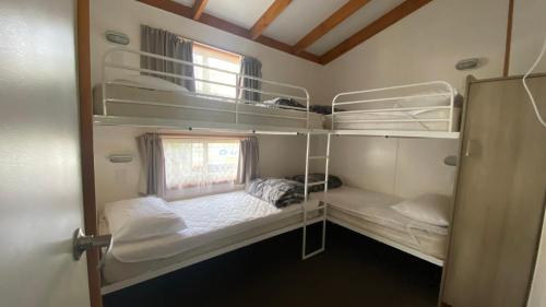 a room with two bunk beds and a window at Twin Dolphins Holiday Park in Tuncurry