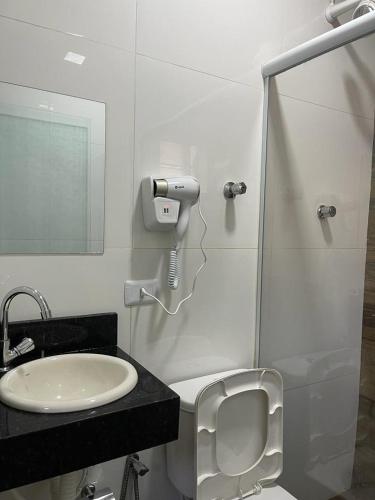 a bathroom with a sink and a toilet and a mirror at Hotel Carrão in Sao Paulo