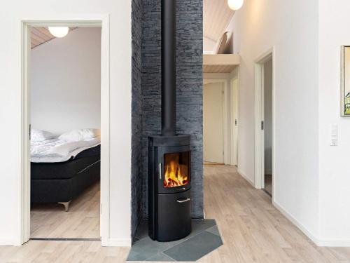 Una chimenea negra en una habitación con dormitorio en Holiday home Brovst XIX, en Brovst