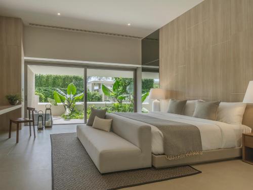 a bedroom with a large bed and a couch at Veyla Natai Residences - Luxury Pool Villa in Khok Kloi