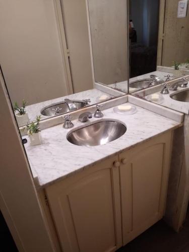 baño con 2 lavabos y espejo grande en Comodo Departamento en San Juan