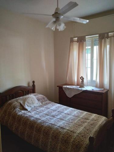 a bedroom with a bed and a ceiling fan at Comodo Departamento in San Juan