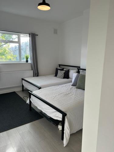 1 Schlafzimmer mit 2 Betten und einem Fenster in der Unterkunft Hackney Apartment in London