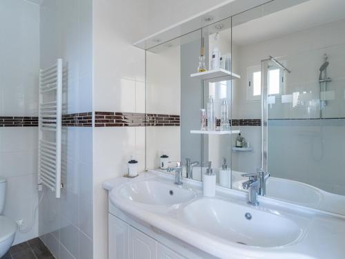 a white bathroom with a sink and a mirror at Maison à Mimizan avec jardin et piscine privée pour 6 personnes - FR-1-50-95 in Mimizan