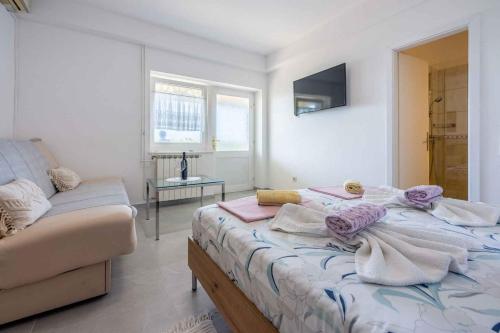 Klanfari的住宿－Apartment in Crikvenica 5316，一间卧室配有一张床和一张沙发