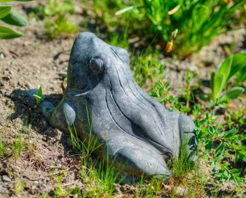 a statue of a bird sitting in the grass at Waldhotel Sonnenberg in Bollendorf