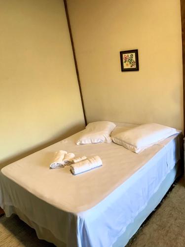 a bed in a room with two towels on it at Chalé nas Árvores in São Francisco Xavier