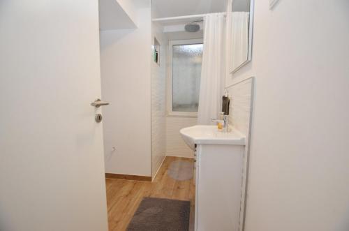 a white bathroom with a sink and a window at Apartments and rooms with WiFi Rovinj - 20857 in Rovinj