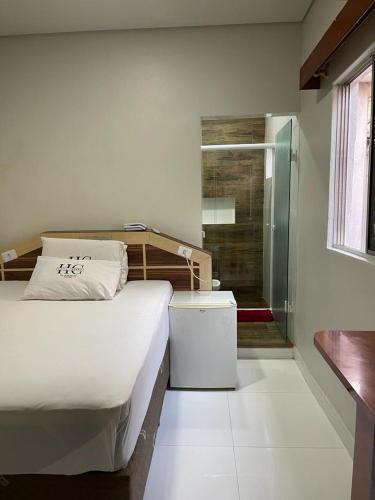 a bedroom with a bed and a walk in shower at Hotel Carrão in Sao Paulo