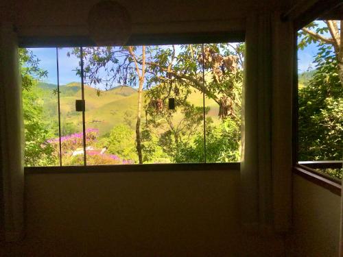 a window with a view of a mountain view at Chalé nas Árvores in São Francisco Xavier