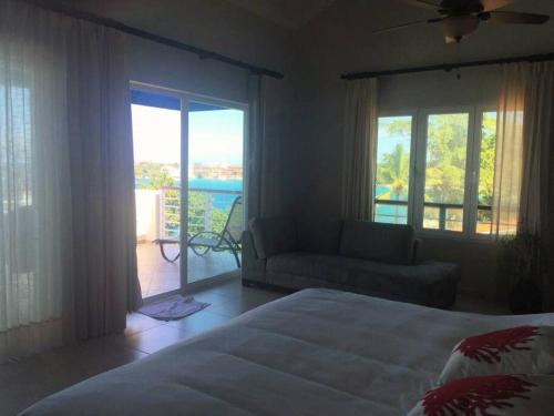 um quarto com uma cama, um sofá e uma varanda em Penthouse de lujo con increíble vista al mar em Sosúa