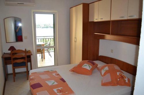 ロヴィステにあるApartments and rooms by the sea Loviste, Peljesac - 21096のベッドルーム1室(オレンジ色の枕が付いたベッド1台付)