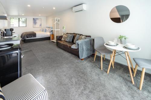 een woonkamer met een bank, een bed en een tafel bij St Albans Gem Single level studio with Queen bed in Christchurch