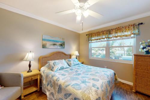 sypialnia z łóżkiem i wentylatorem sufitowym w obiekcie Ocean Heaven w mieście Satellite Beach