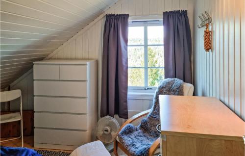 a room with a desk and a table and a window at Amazing Home In Risr With Wifi in Risør
