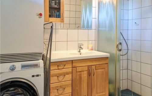 a kitchen with a sink and a washing machine at Amazing Home In Risr With Wifi in Risør