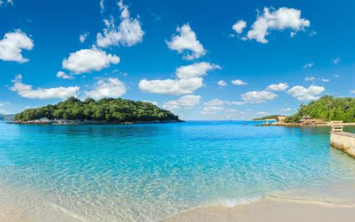 an island in the ocean with a sandy beach at Omnia Apartments in Ksamil