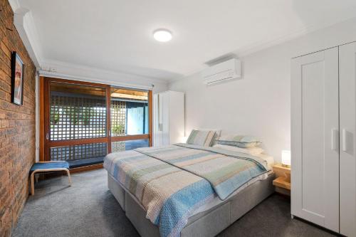 biała sypialnia z łóżkiem i oknem w obiekcie Redwood Beach House - with 10 percent off until September w mieście Cowes