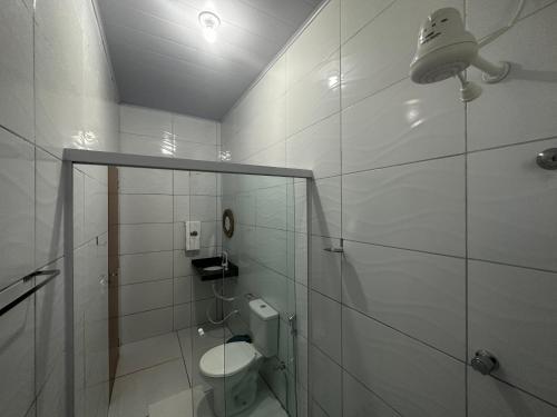 een witte badkamer met een toilet en een douche bij POUSADA E AGENCIA CLEDIO TURISMO in Barreirinhas