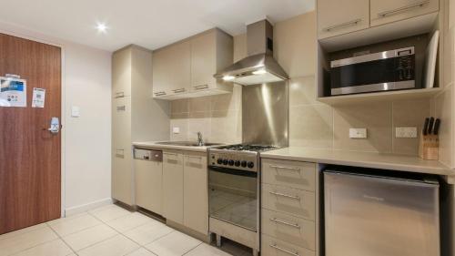 a kitchen with a stove top oven next to a sink at Chalet Hotham 17 in Mount Hotham