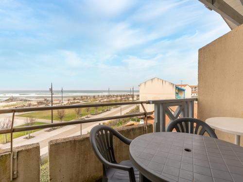 un balcon avec une table et des chaises et une vue sur la plage dans l'établissement Appartement avec vue sur l'océan, balcon, et tout confort, à Mimizan pour 6 personnes - FR-1-50-79, à Mimizan