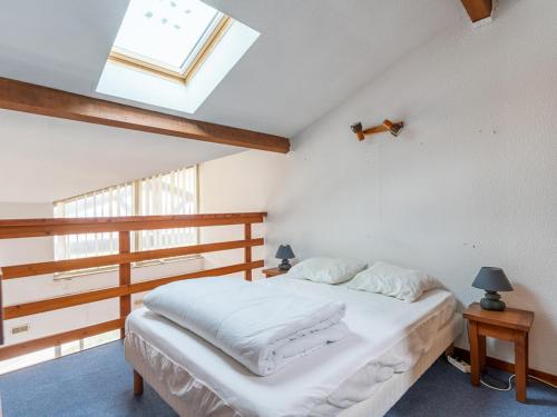 - une chambre avec un lit doté de draps blancs et une lucarne dans l'établissement Appartement avec vue sur l'océan, balcon, et tout confort, à Mimizan pour 6 personnes - FR-1-50-79, à Mimizan