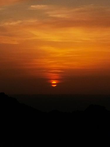 a sunset with the sun in the sky at Petra Desert Dream Hotel in Wadi Musa
