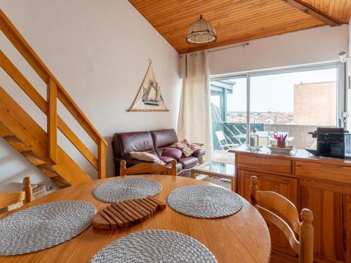 une salle à manger avec une table et un canapé dans l'établissement Mimizan Plage: Appartement T2 Mezzanine 2 étoiles, 4 pers, vue océan, parking inclus - FR-1-50-86, à Mimizan