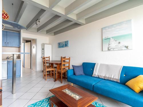 un salon avec un canapé bleu et une table dans l'établissement Mimizan Plage: Appartement 6 Pers, 2 Étoiles, Ménage Inclus, Parking, Ascenseur - FR-1-50-83, à Mimizan