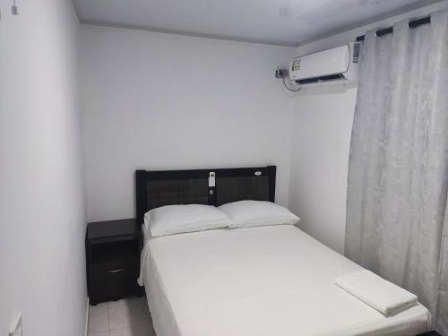 a bedroom with a white bed and a window at San San Andrés Magic House 0 by BBBSAI in Buenavista