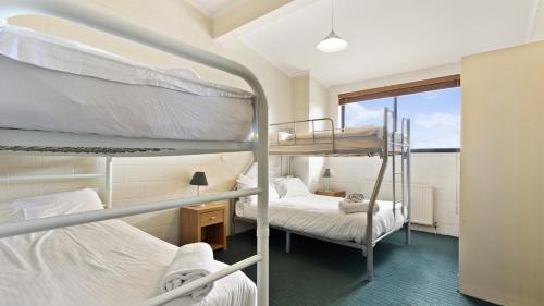 two bunk beds in a room with a window at Alpine Heights 04 in Mount Hotham