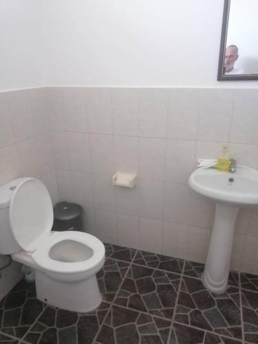 a bathroom with a toilet and a sink at Yuli's Homestay in Kuta Lombok