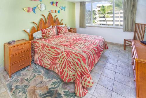 a bedroom with a bed and a dresser and a window at Condo On the Ocean, Lagoon and Garden - Hale Kona Kai 411 by Casago Kona in Kailua-Kona