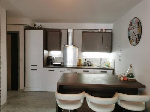 une cuisine avec une table en bois et des armoires blanches dans l'établissement Logement entier, appartement Antibes-Juan les Pins, à Antibes