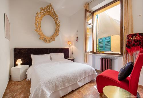 - une chambre avec un lit blanc et une chaise rouge dans l'établissement Billie's Flat RED - art & design apt in Verona historic centre, à Vérone