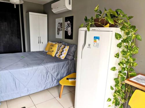een kamer met een koelkast naast een bed bij Tiny House Paraiso Minicasas Com Hidromassagem in Pouso Alegre