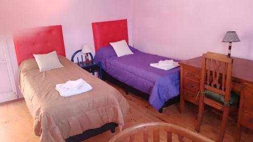 a bedroom with two beds and a desk and a dresser at 9 de julio in Villa Mercedes