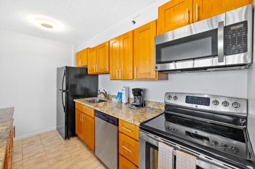 a kitchen with stainless steel appliances and wooden cabinets at 1BR with Stunning Ocean Views, Near Beach & Parking in Honolulu