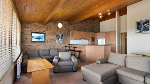 sala de estar con sofá y sillas y cocina en Lawlers 34 en Mount Hotham